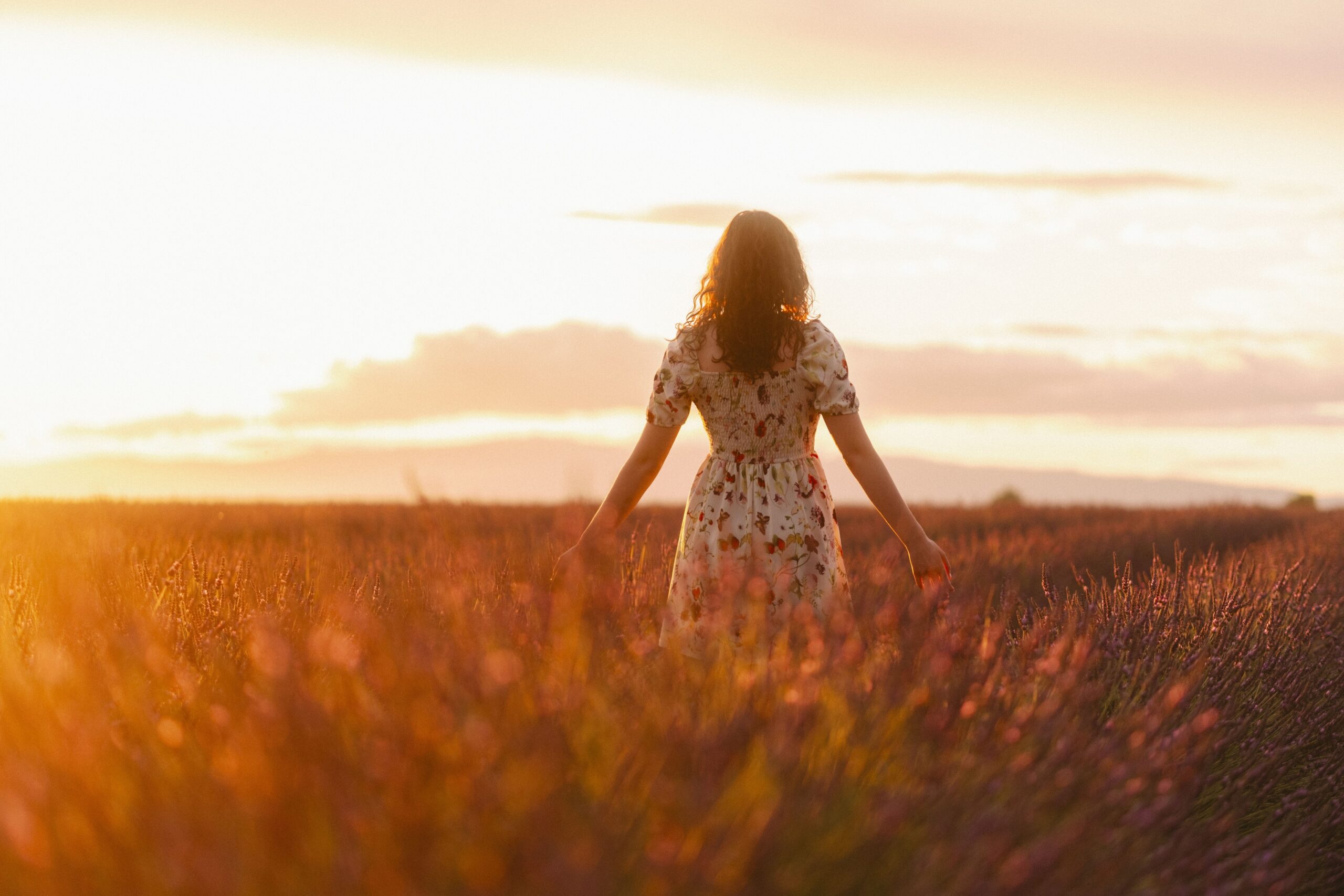 A woman walks through a lavender field in Valensole, Provence during a stunning sunset. Psychologue psychothérapeute paris 15 Anaïs Farhat adulte visio téléconsultation en ligne
